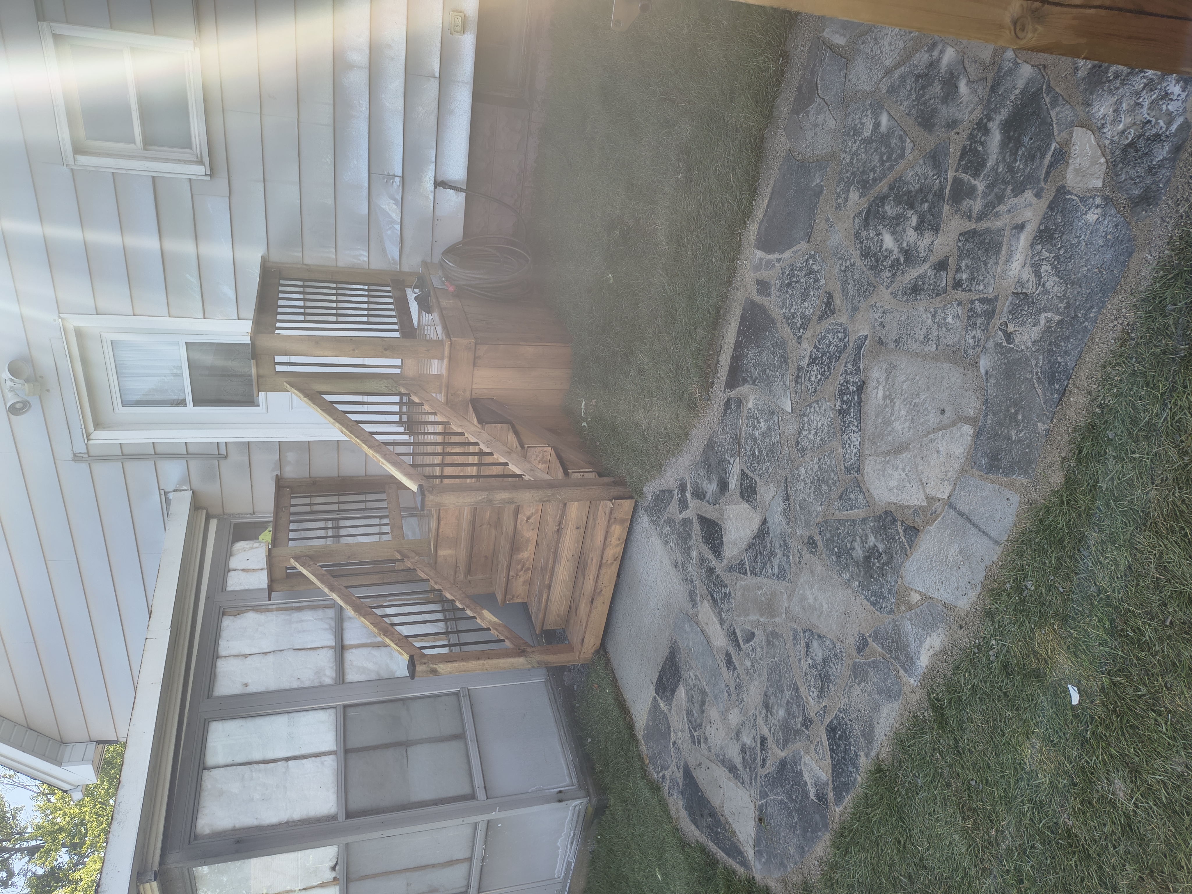 Custom pressure-treated deck and stairs meeting the flagstone patio