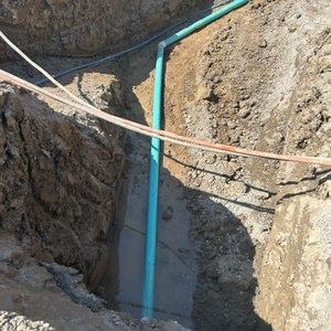 Underground water and sewer servicing in an excavated trench
